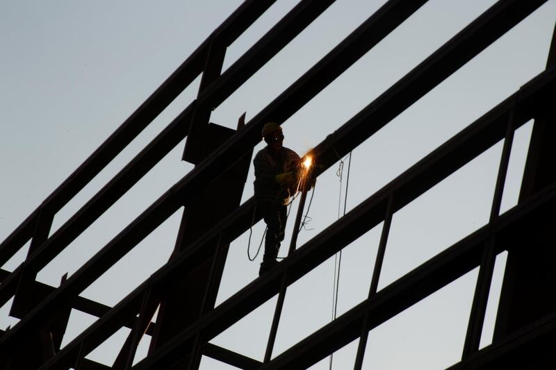 A welder works on a joint at a construction site in Beijing. Reuters
