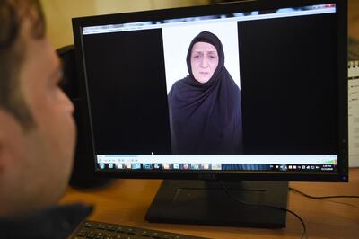 In this picture taken on November 12, 2020, a man watches a video of Afghan woman Nasreen, who walked free from jail in September after confessing to being members of the Taliban's ultra-violent Haqqani network, on a computer screen in Kabul. Female assassins who lured an Afghan security official to his death with promises of sex before shooting him and dumping his body at a cemetery are among thousands of Taliban criminals freed as part of a fragile peace plan. - TO GO WITH 'Afghanistan-conflict-Taliban-women-prisoners, FOCUS' by Elise BLANCHARD
 / AFP / Wakil KOHSAR / TO GO WITH 'Afghanistan-conflict-Taliban-women-prisoners, FOCUS' by Elise BLANCHARD
