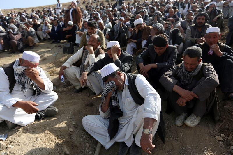 Afghan men cry near the grave of a victim who died during Friday night's suicide attack at the Shiite mosque in Kabul, Afghanistan, Saturday, Oct. 21, 2017. The Islamic State group is claiming responsibility for a suicide bombing attack on a Shiite mosque in Kabul that killed at least 39 and wounded at least 41. (AP Photo/Rahmat Gul)