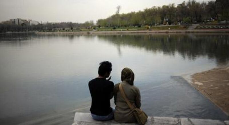 A couple sits by the bank of Zayandeh Rud river in the city of Isfahan. Many Iranians struggle daily to develop romantic relationships in the face of their regime's harsh social dictates.