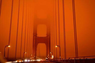 Cars drive along the Golden Gate Bridge under an orange smoke filled sky at midday in San Francisco, California. AFP 