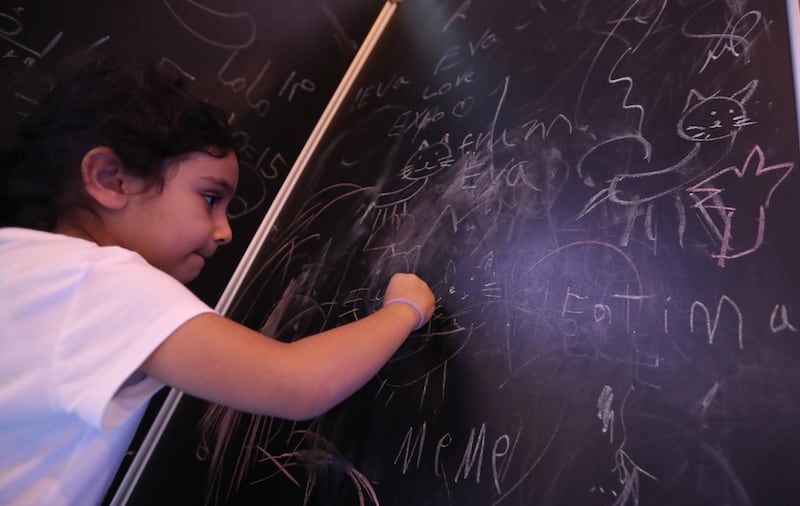 A child writes on a chalkboard. EPA