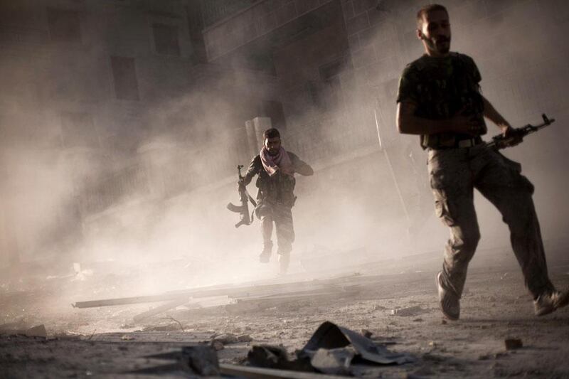FSA fighters run after attacking a Syrian Army tank during fighting in the Izaa district. Manu Brabo / AP Photo