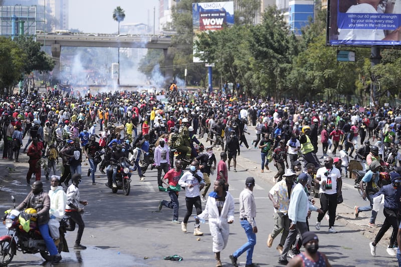Protesters scatter as Kenyan police spray water on the crowd. AP