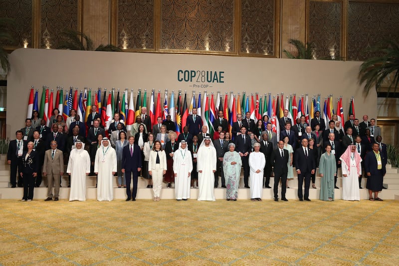 Delegates pose for a photo at the opening ceremony for Pre-Cop28