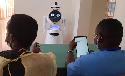 Engineers give instructions to a high-tech robot developed by Zora Bots, a Belgium-based company, and donated by the United Nations Development Program (UNDP) at the Kanyinya treatment centre that treats coronavirus disease (COVID-19) patients, in Kigali, Rwanda May 29, 2020. Picture taken May 29, 2020. REUTERS/Clement Uwiringiyimana