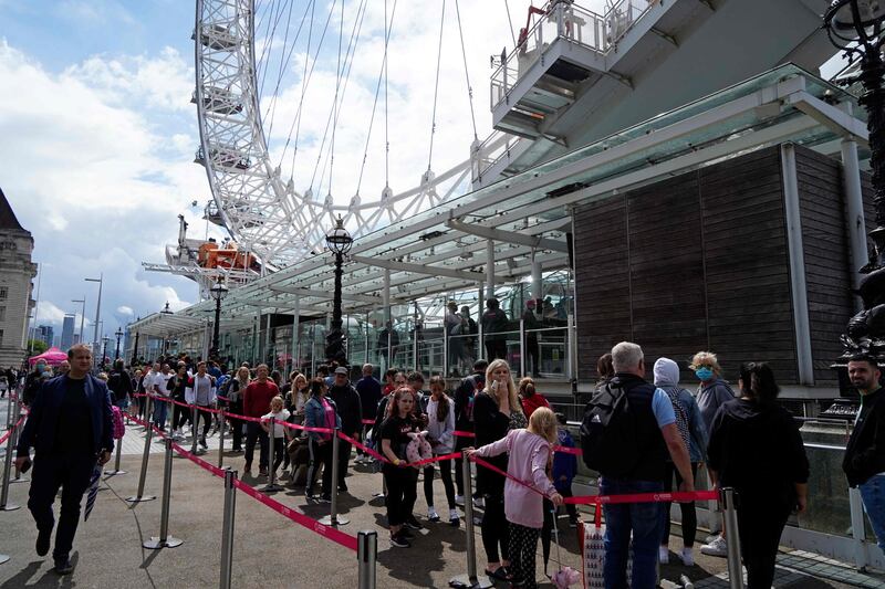 Customers queue for the London Eye attraction on the South Bank of the River Thames in central London.