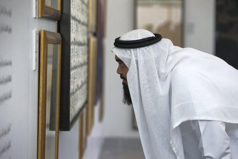 ABU DHABI, UNITED ARAB EMIRATES - An attendee looking at an art on display at the Al Burda Festival, Shaping the Future of Islamic Art and Culture at Warehouse 421, Abu Dhabi.  Leslie Pableo for The National for Melissa Gronlund’s story