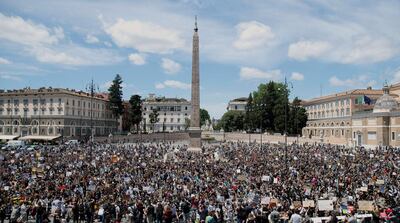 People gather calling for justice for George Floyd, who died May 25 after being restrained by police in Minneapolis, USA, in Romeâ€™s Peopleâ€™s Square, Sunday, June 7, 2020. People have been protesting throughout Italy to denounce the police killing of George Floyd and show solidarity with anti-racism protests in the U.S. and elsewhere. (Roberto Monaldo/LaPresse via AP)