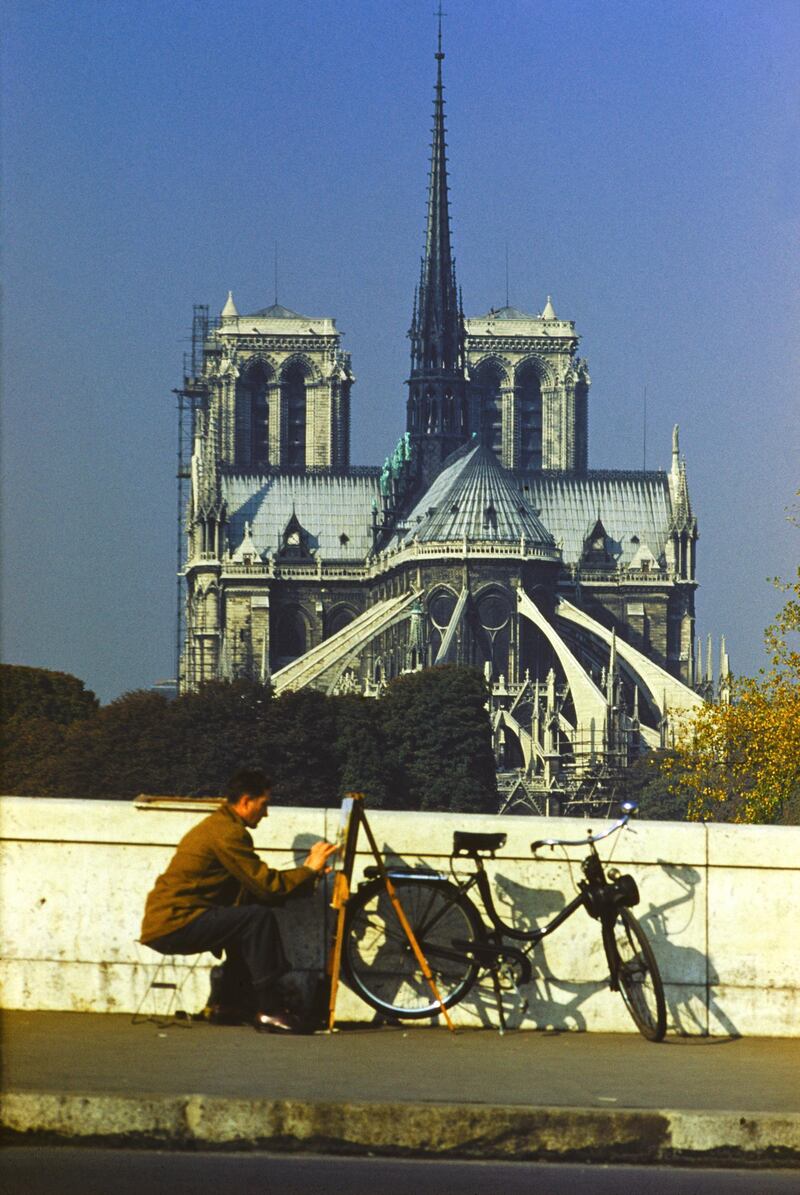 A man uses an easel to paint next to the Notre Dame de Paris, Paris, France, circa 1960. (Photo by Ernst Haas/Ernst Haas/Getty Images)