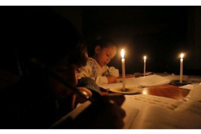 Palestinian children do their homework by candlelight during a power cut in Gaza City this week.