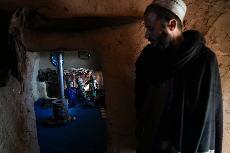 Hamid Abdullah outside a room where his children are playing at a settlement near Herat. Mr  Abdullah is selling his young daughters into arranged marriages, desperate for money to treat his chronically ill wife, who is pregnant with their fifth child.  AP Photo