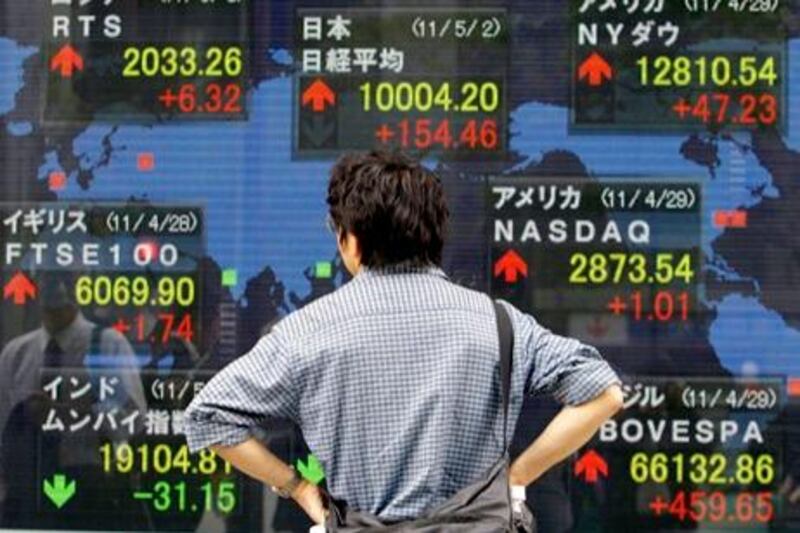 A man looks at an electric stock board of a securities firm in Tokyo, Monday, May 2, 2011 indicating rise of global share prices, including Japan's Nikkei 225 index, top center, that gained 154.46 points and closed at 10,004.20, recovering the 10,000 level. (AP Photo/Koji Sasahara) *** Local Caption ***  KSX104_Japan_World_Markets.jpg