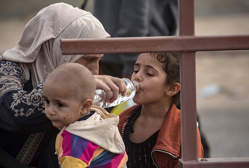 A Palestinian child drinks water as they evacuate to the southern Gaza Strip. EPA