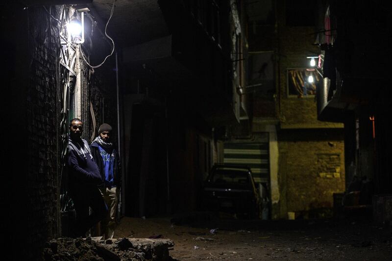 Two Egyptians stand in front of their house on the street leading to the church where an explosion occurred leaving one casualty, in Cairo. AFP