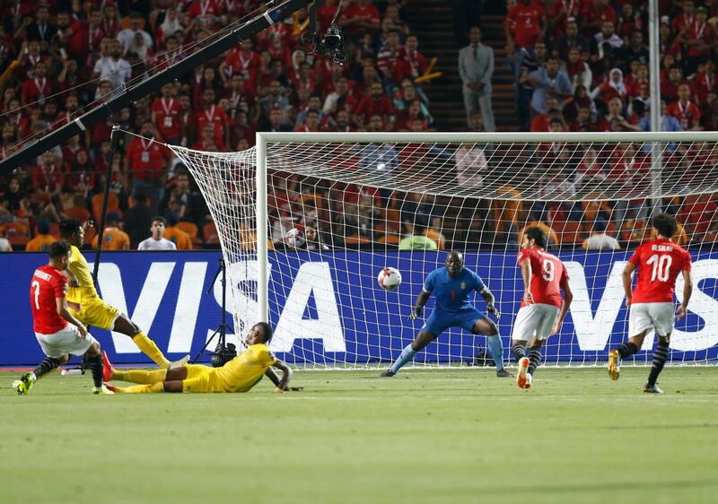 Egypt's Mahmoud Hassan, left, scores during the group A soccer match between Egypt and Zimbabwe at the Africa Cup of Nations at Cairo International Stadium in Cairo, Egypt, Friday, June 21, 2019. Egypt won 1-0. (AP Photo/Ariel Schalit)