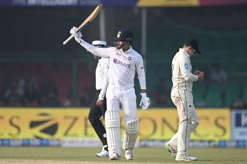 Shreyas Iyer raises his bat after scoring a half-century at the Green Park Stadium in Kanpur. AFP
