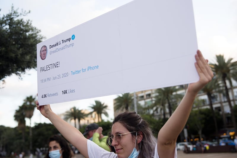 An Israeli woman holds a sign as she protests against Israel goverment's plan to annex parts of the West Bank in Tel Aviv, Israel. Getty Images