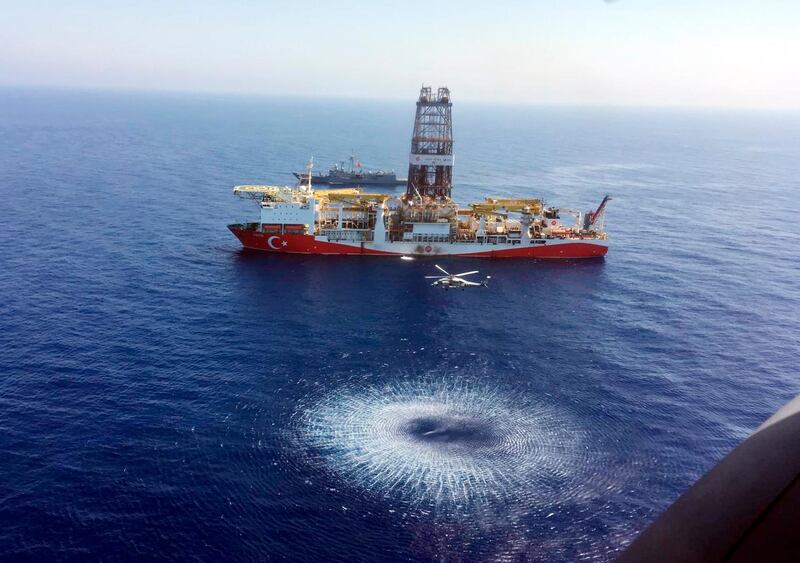 In this Tuesday, July 9, 2019 photo, a helicopter flies over Turkey's drilling ship, 'Fatih' dispatched towards the eastern Mediterranean, near Cyprus. Turkish officials say the drillships Fatih and Yavuz will drill for gas, which has prompted protests from Cyprus. (Turkish Defence Ministry via AP, Pool)