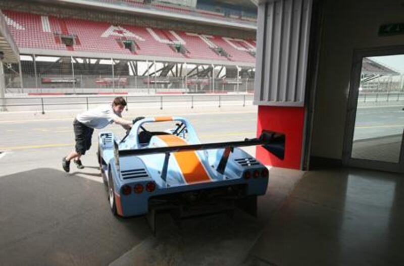 Tim Murdoch, a race mechanic from the UK, wheels David Field's SR5 Radical sports car back into the pits at Dubai Autodrome. The SR5 is one of four classes of racer that competes in the Gulf Radical Cup.