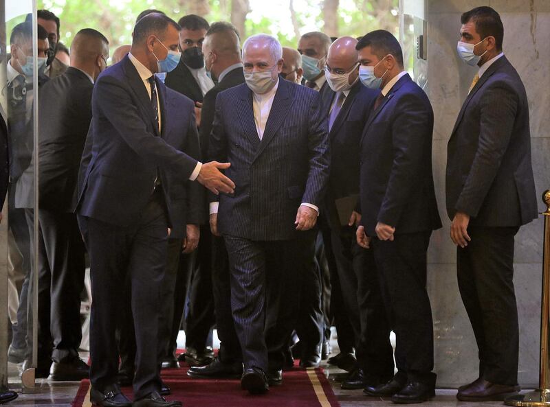 Mr Zarif, centre, is welcomed to Baghdad. He is also expected to visit the southern city of Najaf. AFP