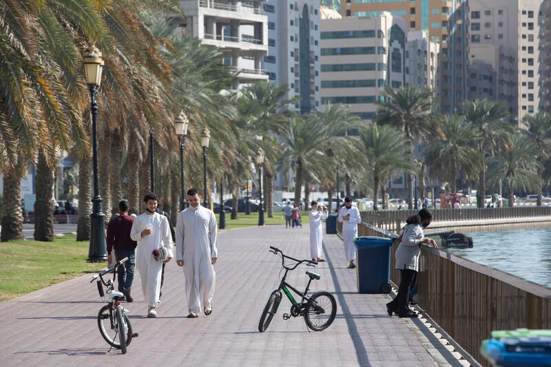 People take a walk on the Buhaira Corniche in Sharjah on Friday as the emirate ushered in its first three-day weekend. All photos: Antonie Robertson / The National