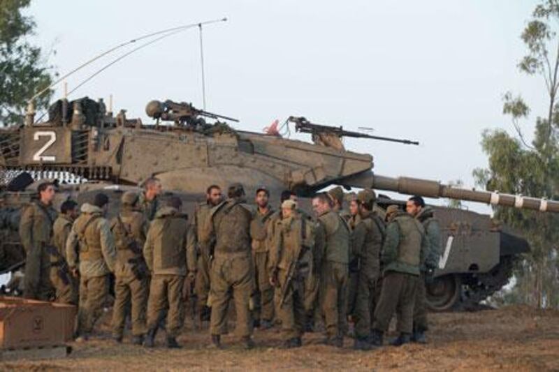 Israeli soliders on the Israel-Gaza border gather at a deployment area. A planned ground assault has been suspended by Israel overnight.