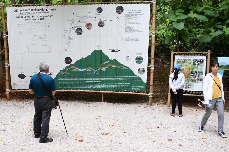 Visitors looking at an infographic illustrating the rescue of the “Wild Boars” football team. AFP