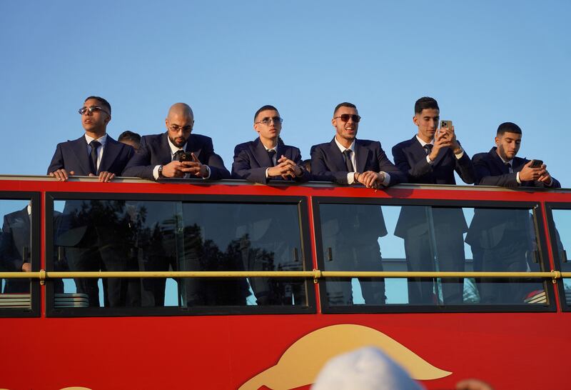The Morocco players stand on their open-top bus. Reuters 
