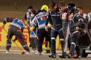 TOPSHOT - Stewards and medics attend to Haas F1's French driver Romain Grosjean after a crash at the start of the Bahrain Formula One Grand Prix at the Bahrain International Circuit in the city of Sakhir on November 29, 2020. / AFP / POOL / HAMAD I MOHAMMED