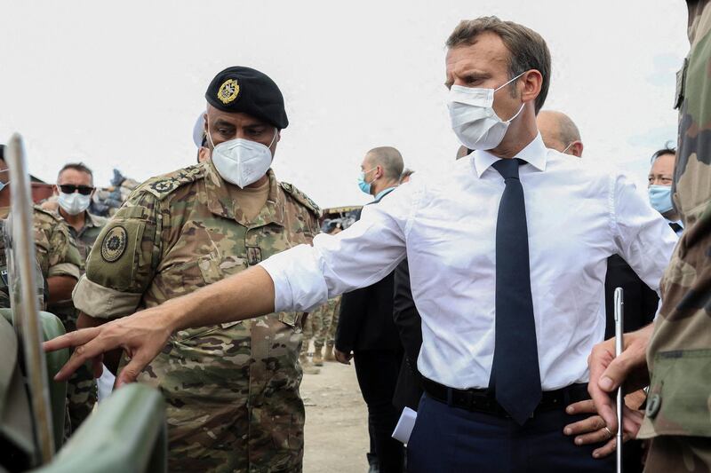 Emmanuel Macron gestures toward a board as he meets the military mobilised to help to rebuild the Beirut port. via AP