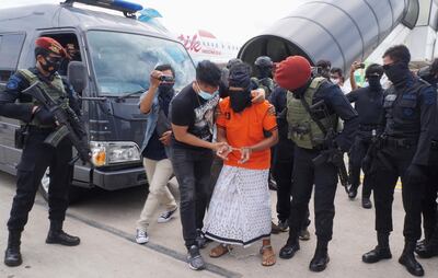 Police escort 57-year-old Zulkarnaen, a senior leader of the Al-Qaeda-linked Jemaah Islamiyah (JI), who had been on the run for his alleged role in the 2002 Bali bombings, upon arrival at Jakarta’s Soekarno-Hatta International Airport in Tangerang on December 16, 2020. (Photo by FAJRIN RAHARJO / AFP)