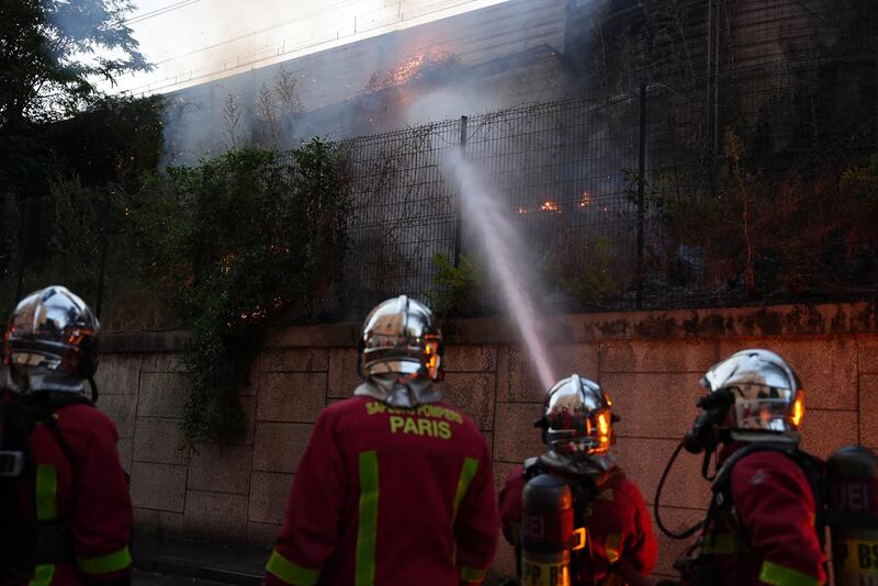 Firefighters tackle a blaze near a protest in Nanterre, west of Paris, after French police killed a teenager who refused to stop for a traffic check in the city. AFP