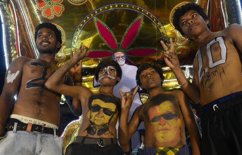 Fans display body paint with a portrait of Rajinikanth before attending the early morning show. AFP