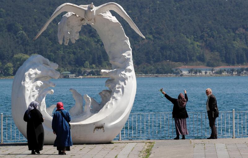 Senior Turkish citizens who were not allowed to go out of their houses since April 4 enjoy a sunny day next to the sea, after being exempted from curfew for four hours, in Istanbul. Reuters