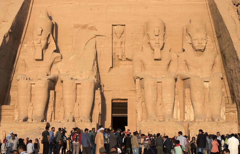 (FILES) In this file photo taken on October 22, 2016 tourists gather outside the temple of Abu Simbel, south of Aswan in upper Egypt, to witness the sun illuminate the inner sanctuary. Fifty years ago one of the world's biggest archeological rescue operations was successfully concluded after the ancient, massive Egyptian temple complex was dismantled and hoisted to higher ground to prevent its flooding by the damming of the Nile River. The groundbreaking UNESCO-led project to relocate around 20 gigantic monuments in Abu Simbel complex was officially concluded on September 22, 1968, after an eight-year international effort involving hundreds of workers. / AFP / MOHAMED EL-SHAHED
