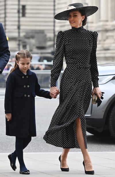 Kate, Duchess of Cambridge wears a black and white polka dot dress by Alessandra Rich as she arrives for the service of thanksgiving for the life of Prince Philip, the late Duke of Edinburgh, with her daughter, Princess Charlotte, at Westminster Abbey, London, on March 29, 2022. EPA