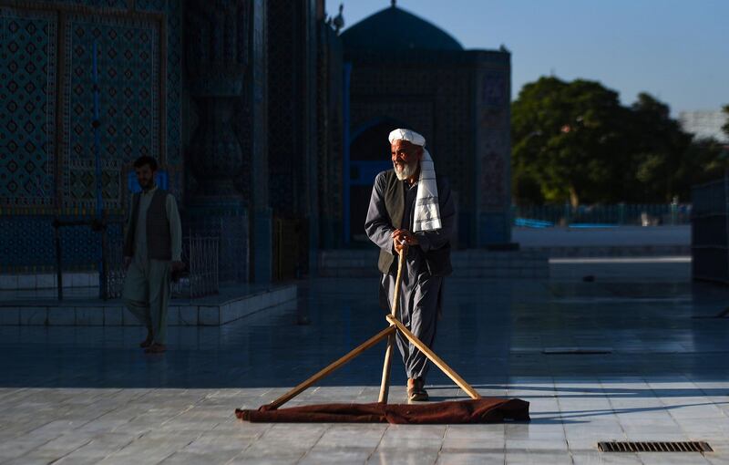 An Afghan man cleans the courtyard of Hazrat-e-Ali shrine. AFP