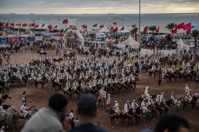 People watch as horse riders wait for their turn to take part in an equestrian show known as Fantasia or Tabourida, in the coastal town of El Jadida, Morocco.