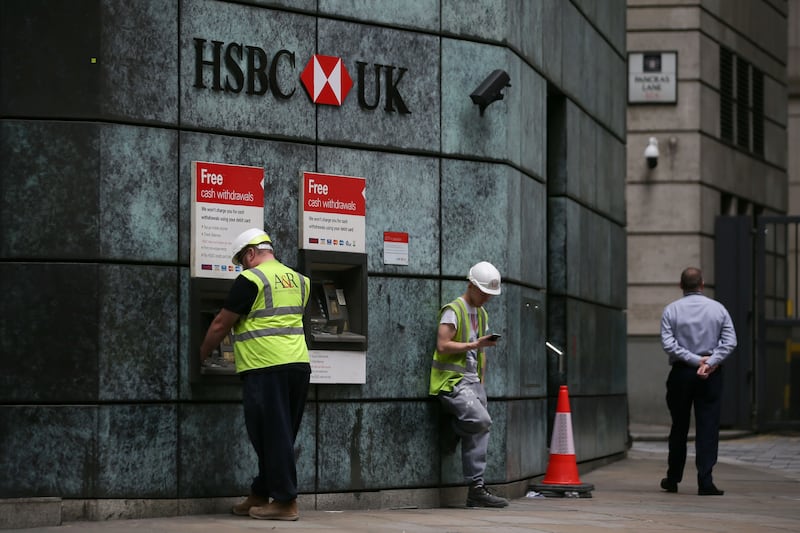 Customers use automated teller machines (ATMs) outside a branch of a HSBC bank in the City of London on July 31, 2017.
HSBC said profits were up in the first half of the year after a turbulent 2016 which saw huge writedowns and restructuring costs as it laid off thousands of staff. Like many global banks, HSBC has struggled to boost profits as China's economy slows and uncertainty caused by Britain's looming exit from the European Union casts a shadow over the sector. / AFP PHOTO / Daniel LEAL-OLIVAS