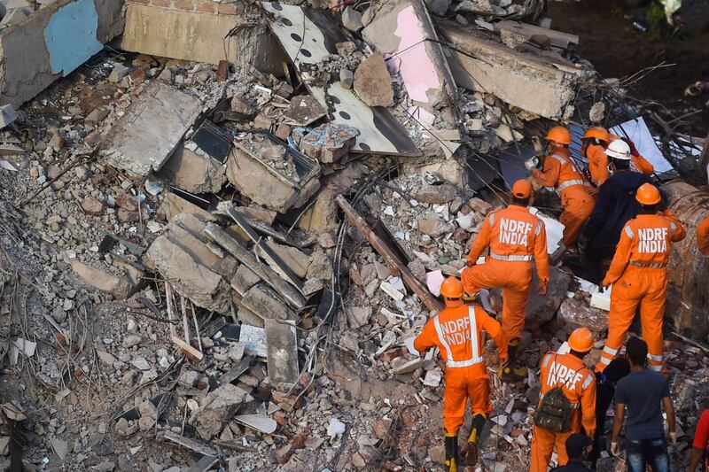 Rescue workers search for people in the rubble of a collapsed five-storey apartment building in Mahad, about 170 kilometres from India's financial capital of Mumbai.  AFP