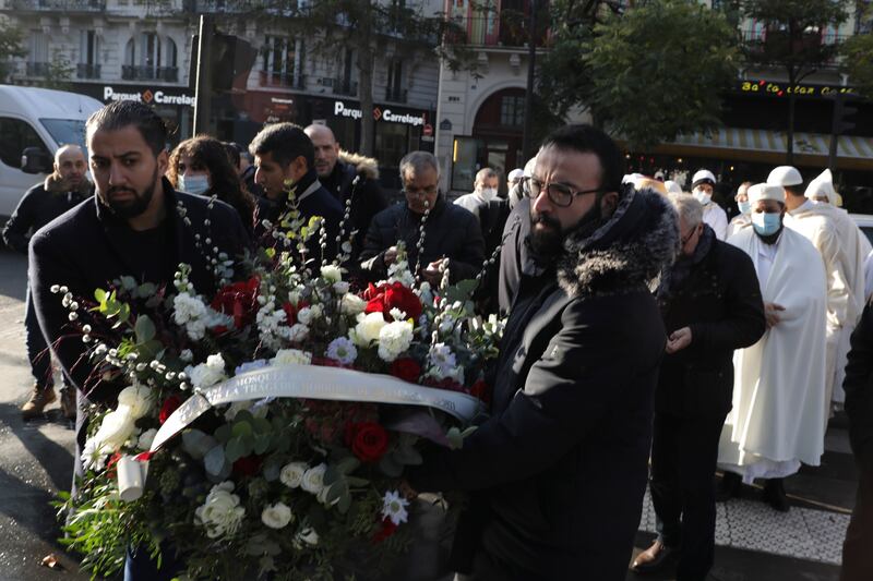 Members of the Muslim community carry a bouquet of flowers outside the Bataclan concert hall. AP