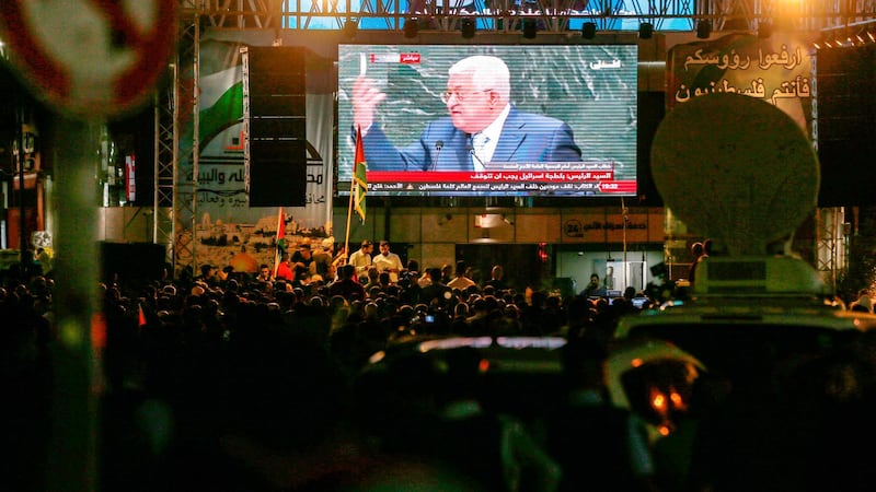 Palestinians watch Palestinian president Mahmoud Abbas on a large screen in the West Bank city of Ramallah. AFP