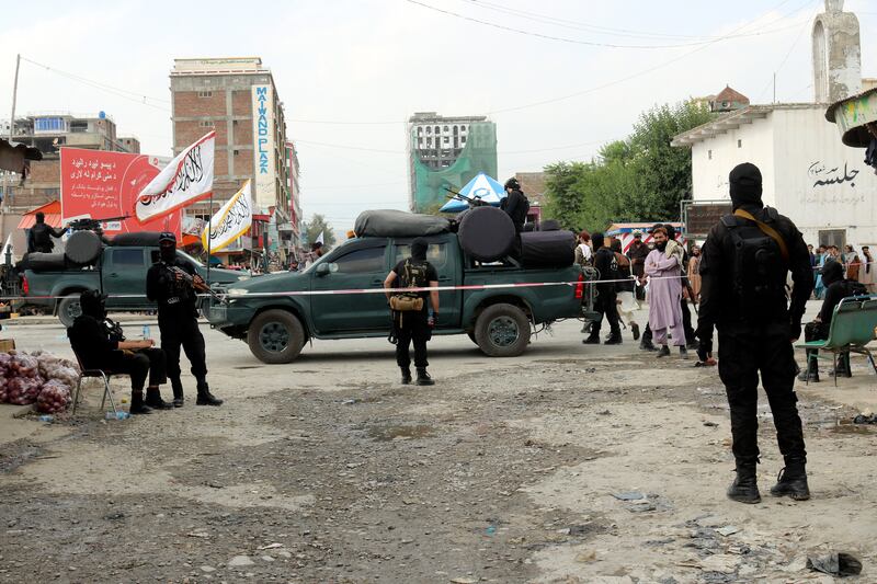 Taliban fighters stand guard at the site of an explosion at a hotel in Afghanistan's south-eastern Khost province. AP