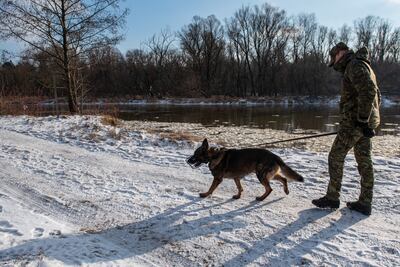A Polish border guard patrols with a dog at the freezing Belarusian border. EPA 