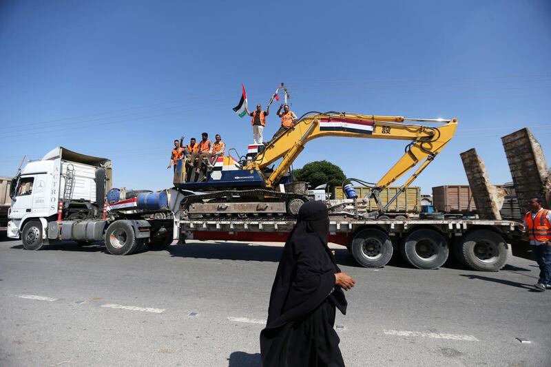 A woman watches as an Egyptian crew celebrates arriving in Gaza. At least 3,000 homes were destroyed or damaged beyond repair, authorities said. Reuters