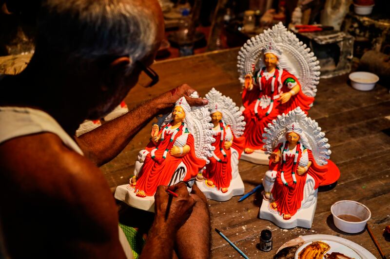 An artist gives finishing touches to an idol of Lakshmi in Kolkata. AP