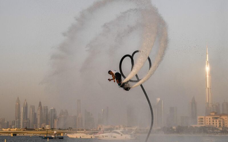 An athlete performs stunts with a water jet pack on the first day of the Dubai watersport festival, organised by the Dubai International Marine Club (DIMC), in the Gulf emirate on June 25, 2020.  / AFP / KARIM SAHIB
