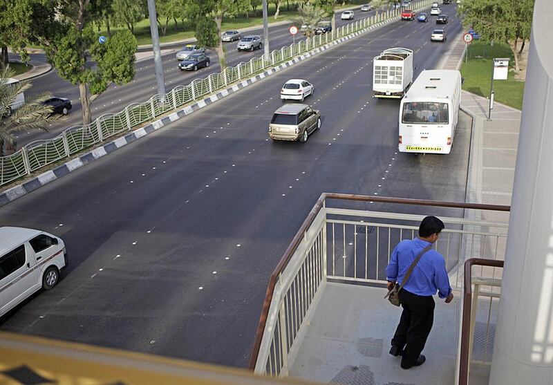 Richard Guimanghan uses a new pedestrian bridge near Carrefour on Airport Road, which was built after the stretch was recognised as a pedestrian accident hotspot. Sammy Dallal / The National