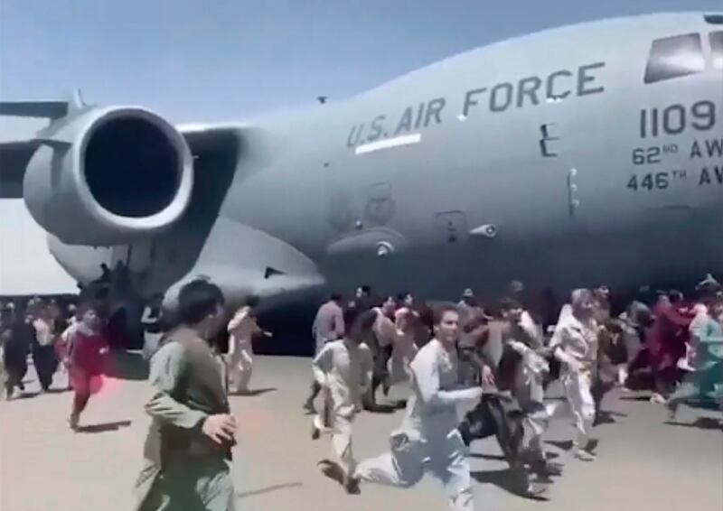 Hundreds of people run alongside a US Air Force transport plane on the runway of the international airport in Kabul on August 16, 2021, desperate to escape the Taliban capture of their country. Some held on to the jet as it took off and fell to their death. AP